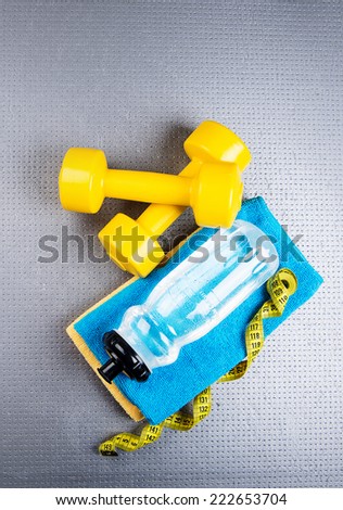 Fitness and healthy life. Conceptual photo Various accessories for sports training, water bottle, towel, measuring tape