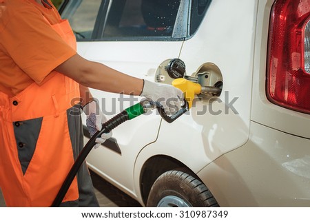 To fill the machine with fuel. car fill with gasoline at a gas station. Gas station pump. filling gasoline fuel in car holding nozzle. Close up.