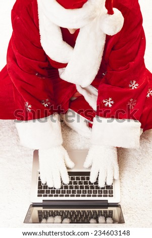 Santa using laptop sending chrisms e-mails