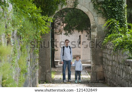father and son on a background of ancient arch in the old garden