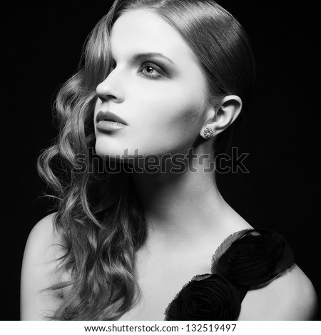 Retro portrait of inaccessible beautiful woman in black dress with smoky eyes and diamond earring. Femme fatale in film noir. Vintage (Hollywood) style. Black & white studio shot