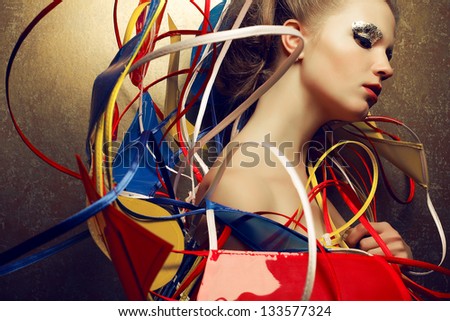 Arty portrait of a fashionable young woman with a perfect golden make-up in a cape done in avant-garde (a-la constructivism and suprematism) and vintage style. Close up. Studio shot