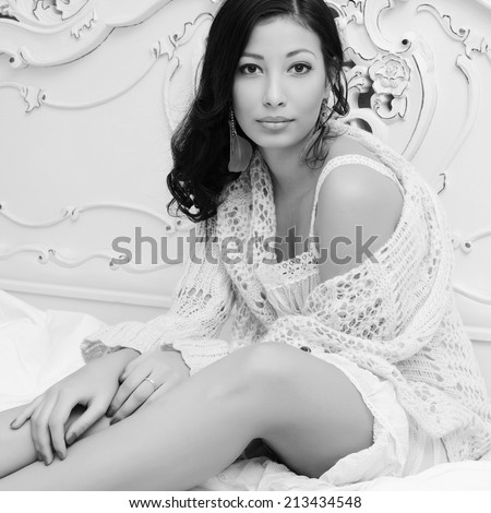 Portrait of young beautiful brunette in stylish underwear sitting in her white vintage bedroom. Healthy skin and natural make-up. Vogue style. Indoor shot