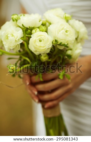 Beautiful wedding bouquet in hands of the bride. Country vintage style. Close up. Outdoor shot