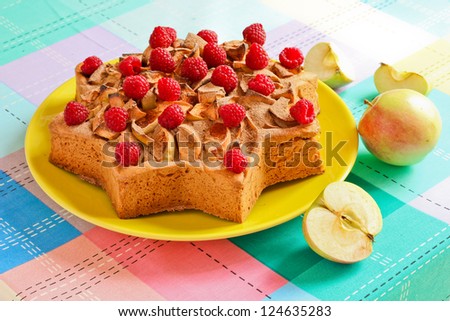 Apple cake in the shape of a star. Adorned with raspberries and apples