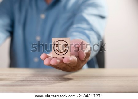 man give wood cube block, smile face icon on hand, customer services best excellent business rating experience. Satisfaction survey concept Stock foto © 