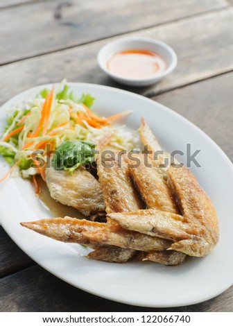 Fried chicken wings on a plate on table wooden thai food