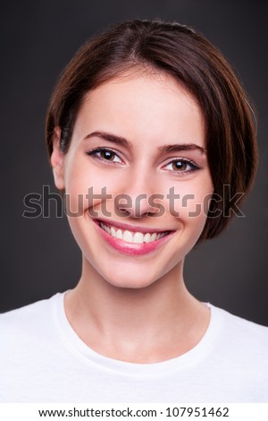portrait of smiley cheerful woman over dark background. studio shot