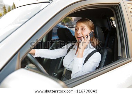 businesswoman driving the car and talking on the phone