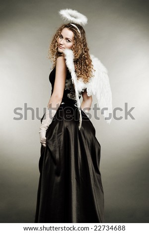 fairy-tale angel in black dress against grey background