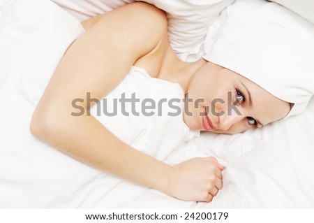 bright picture of young smiley woman lying in the bed