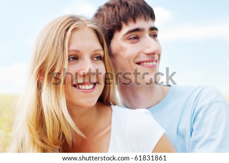 bright portrait of happy smiley couple over blue sky