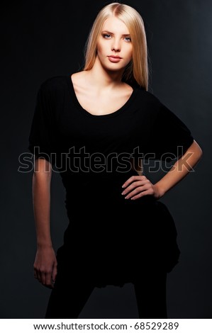 beautiful young blonde posing over dark background
