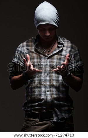 stylish man holding something in his hands over dark background