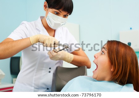 portrait of doctor and scared patient at dentist\'s office