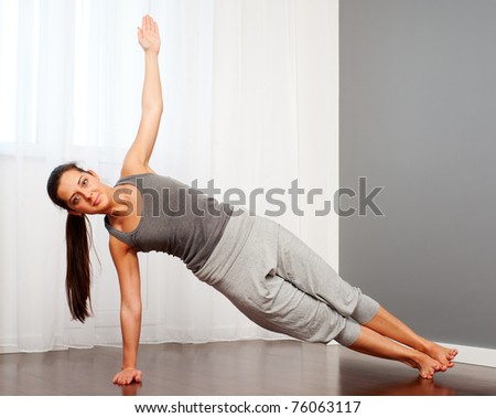 portrait of young woman practicing yoga in room