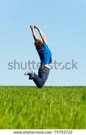happy man jumping on the green field