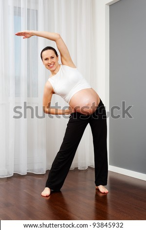 healthy pregnant woman doing gymnastic at home