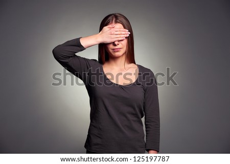 portrait of young woman with closed eyes by hand over dark background