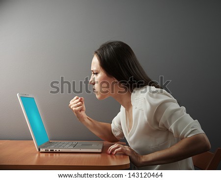 angry woman showing fist to laptop