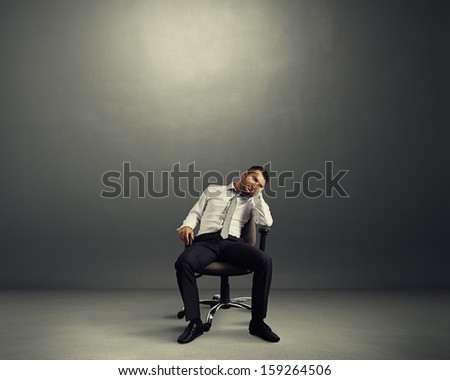 bored businessman sitting in the empty dark room