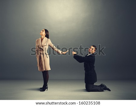 man standing on his knees and apologizing but woman refusing to him