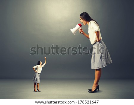 small woman screaming and showing fist to big angry woman