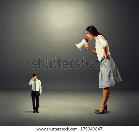 discontented businesswoman screaming at small stressed businessman over dark background