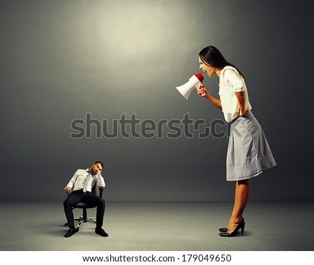 angry young woman screaming at small lazy man