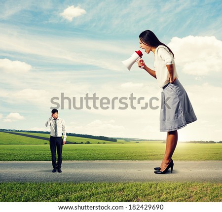 emotional woman boss screaming at small worker in the road