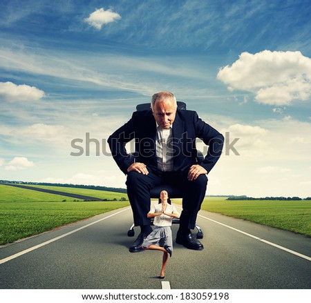 senior man sitting on the office chair and scrutinizing meditation smiley woman at outdoor