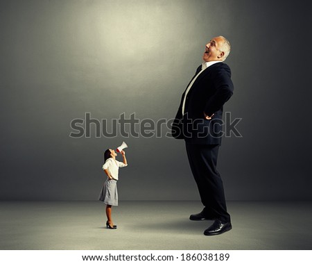 displeased woman and laughing man over dark background