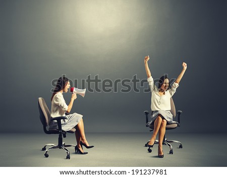 happy woman and angry woman over dark background