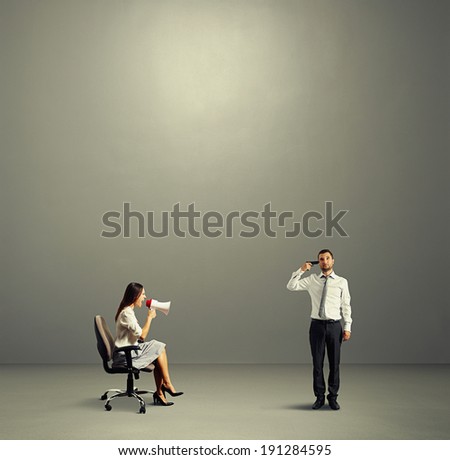 aggressive woman and stressed man with gun over dark background