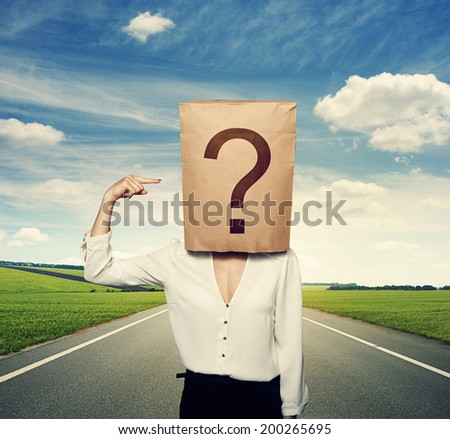 businesswoman with paper bag on the head pointing at question