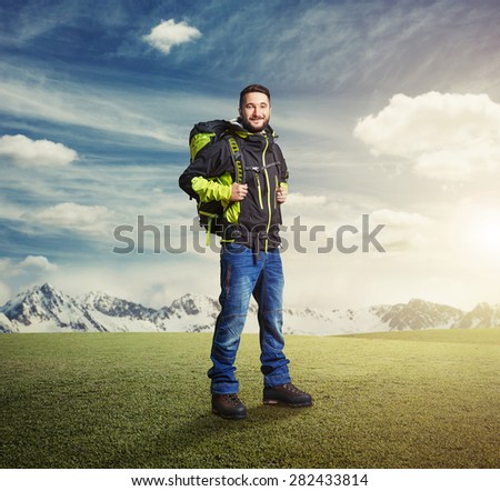 happy tourist with knapsack smiling and looking at camera over beautiful landscape