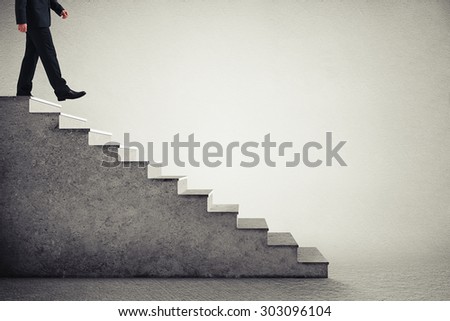 businessman in formal wear walking down the steps  over grey background
