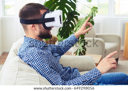 Close-up of athletic sir with beard working in virtual reality glasses sitting on sofa Photo stock © 