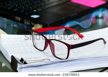 glasses on Stack of papers on work table