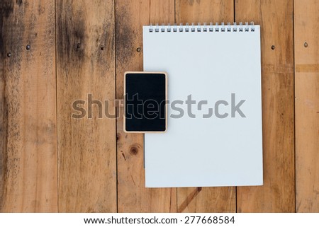 Old blank calendar and black board on wooden planks background
