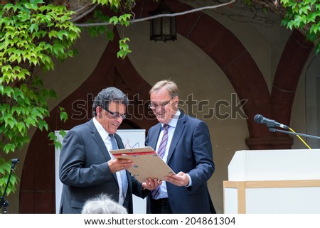BAMBERG, GERMANY - JULY 14 2014: 20 Year Anniversary Celebration of the Migration and Integration Advisory Board of Bamberg. Mayor Andreas Starke handing over a document to the Chairman