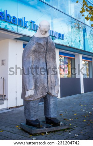 TROSSINGEN, GERMANY - NOVEMBER 05 2014: Statue of a sad man in front of a bank