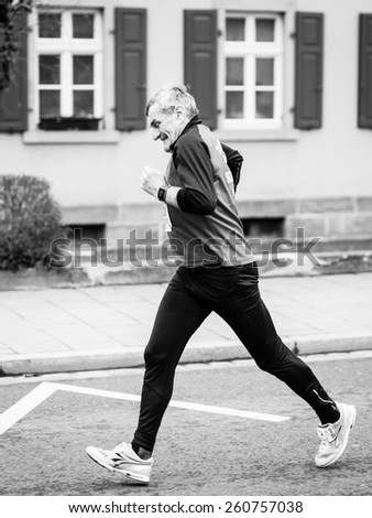 BAMBERG, GERMANY - MARCH 15 2015: Kaiserdomlauf, traditional long distance race event in the City of Bamberg in Bavaria, Germany in March 2015. Old Man running