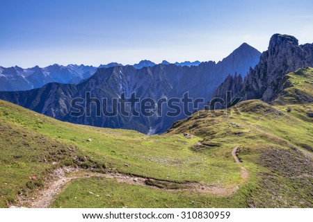 Countryside Adventure Landscape with narrow trekking trails for mountaineering and hiking through the Austrian High Land near Seefeld on a warm and sunny August day with clear sky.