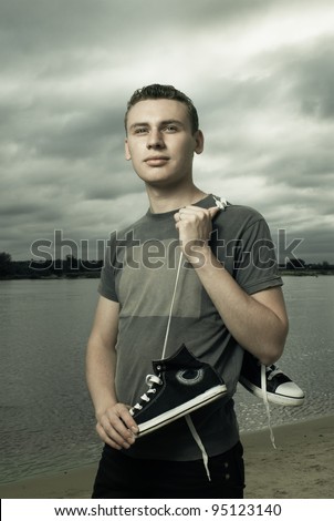 portrait of young man standing on the river bank
