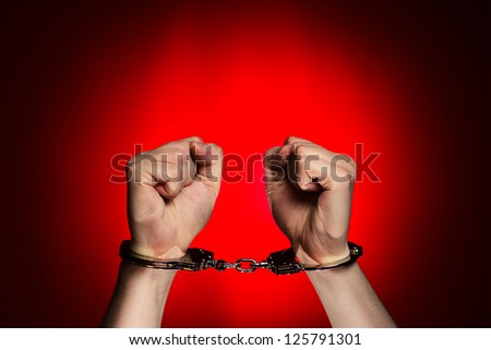 man hands with handcuffs on red background