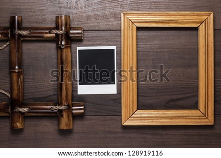empty frames and old photo on the wooden table background
