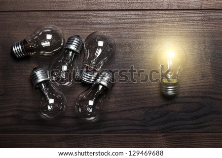 bulbs uniqueness concept on brown wooden background