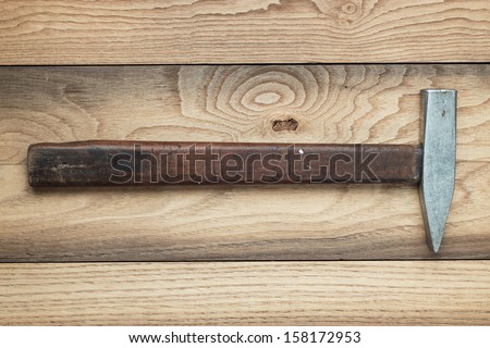 old hammer on the brown wooden background
