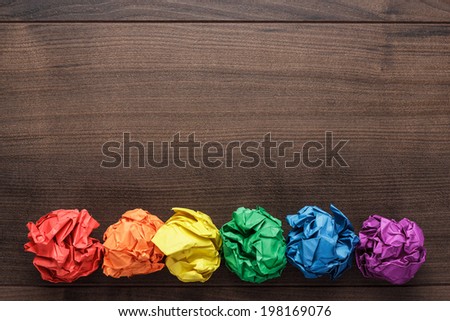crumpled colorful paper on wooden background creative process